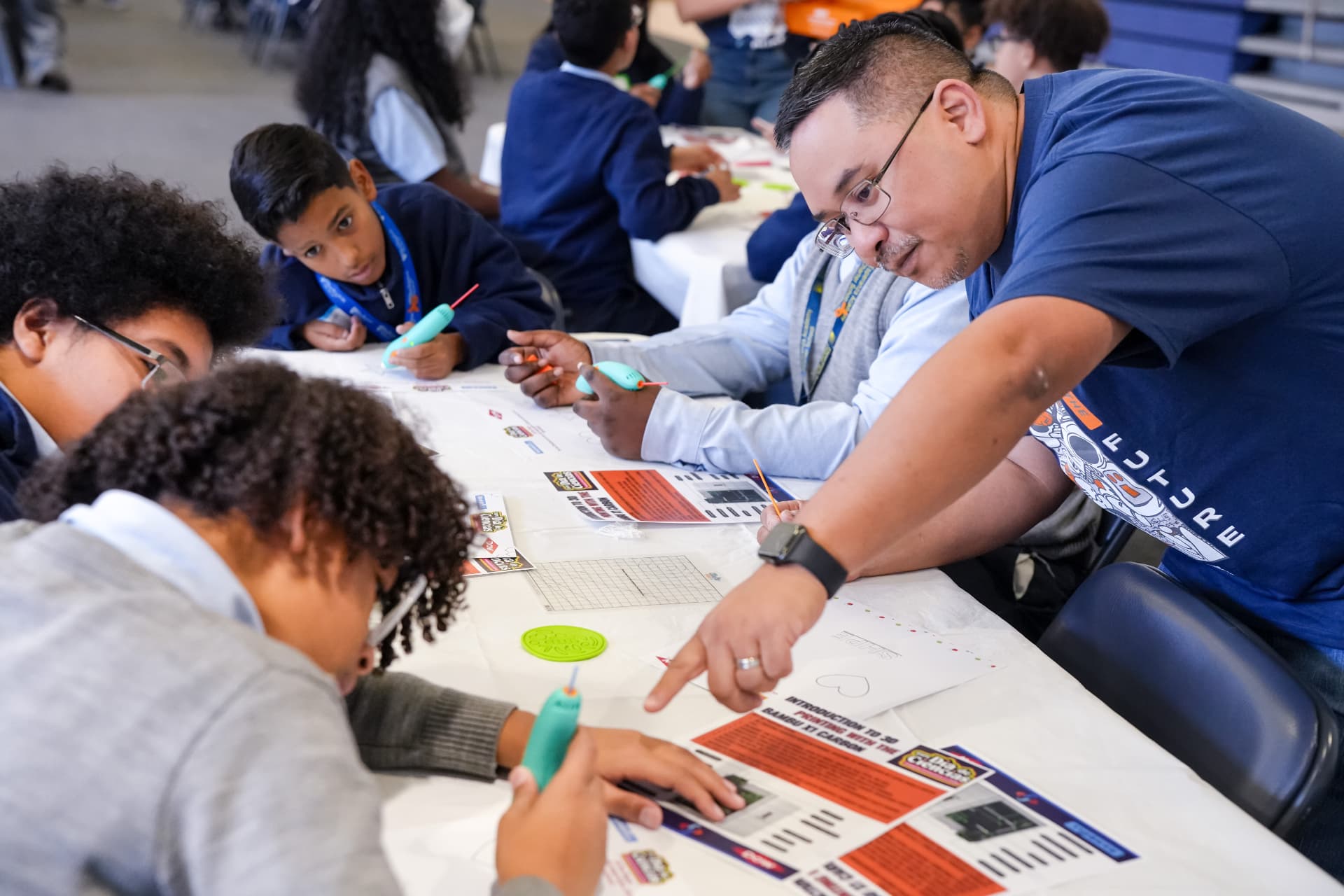 SHPE volunteer guides middle-school students through a hands-on 3D-printing activity at Día de Ciencias.